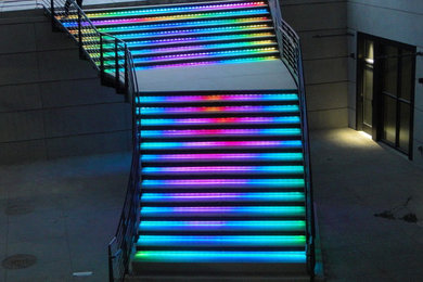 デンバーにある高級な巨大なモダンスタイルのおしゃれな直階段 (コンクリートの蹴込み板、金属の手すり) の写真