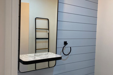Powder room - small shiplap wall powder room idea in Boston with a one-piece toilet, blue walls, a drop-in sink, white countertops and a floating vanity
