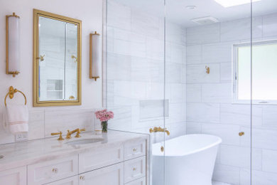 Inspiration for a large transitional master wet room bathroom in Los Angeles with shaker cabinets, white cabinets, a freestanding tub, white tile, marble, white walls, marble floors, an undermount sink, marble benchtops, white floor, a hinged shower door, white benchtops, a double vanity, a built-in vanity and a niche.