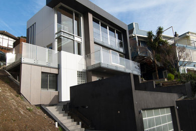 This is an example of a medium sized and white modern detached house in San Francisco with three floors, mixed cladding and a flat roof.
