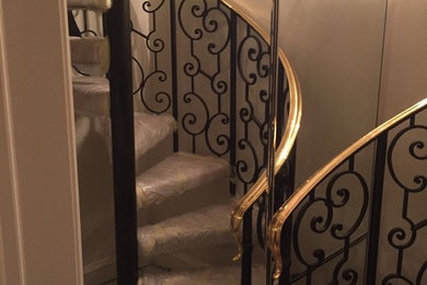 Example of a large carpeted spiral staircase design in Orange County