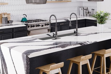 Example of a mid-sized trendy u-shaped bamboo floor and beige floor eat-in kitchen design in Orlando with an undermount sink, shaker cabinets, black cabinets, quartz countertops, white backsplash, ceramic backsplash, stainless steel appliances, an island and white countertops