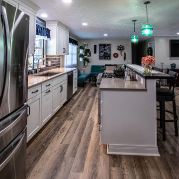 White Kitchen with Blue Tiled Backsplash and Two Tier Island