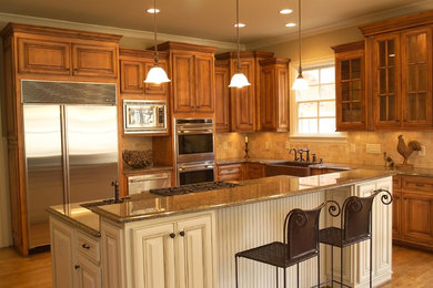 Eat-in kitchen - mid-sized traditional l-shaped medium tone wood floor eat-in kitchen idea in Atlanta with a farmhouse sink, dark wood cabinets, granite countertops, beige backsplash, stone tile backsplash, stainless steel appliances and an island