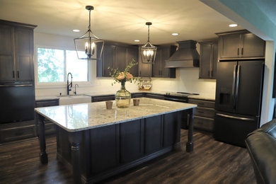 Inspiration for a large farmhouse l-shaped laminate floor and brown floor open concept kitchen remodel in Chicago with a farmhouse sink, shaker cabinets, gray cabinets, granite countertops, an island and white countertops