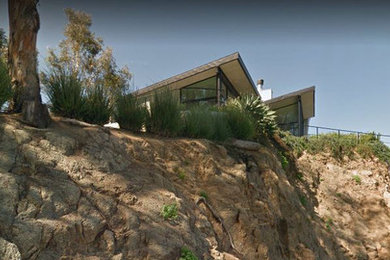 Mid-sized modern gray two-story stucco house exterior idea in Los Angeles with a shed roof and a mixed material roof