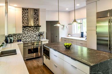 Mid-sized trendy medium tone wood floor and brown floor open concept kitchen photo in Louisville with an undermount sink, flat-panel cabinets, white cabinets, quartzite countertops, multicolored backsplash, ceramic backsplash, stainless steel appliances, an island and white countertops