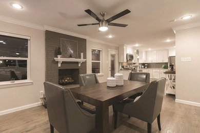 Inspiration for a mid-sized transitional medium tone wood floor and brown floor kitchen/dining room combo remodel in Dallas with beige walls, a standard fireplace and a brick fireplace