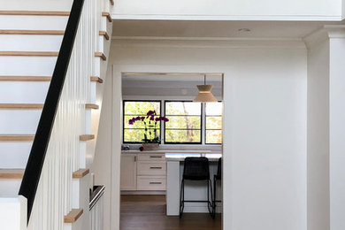 Mid-sized transitional wooden straight wood railing staircase photo in New York with painted risers