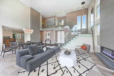 Example of a large trendy open concept porcelain tile and gray floor living room design in Orange County with a standard fireplace and a tile fireplace