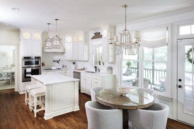 Eat-in kitchen - large shabby-chic style u-shaped dark wood floor and brown floor eat-in kitchen idea in Atlanta with an undermount sink, raised-panel cabinets, white cabinets, quartz countertops, white backsplash, ceramic backsplash, stainless steel appliances, an island and white countertops