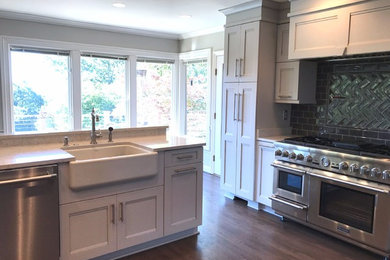 Large medium tone wood floor and brown floor eat-in kitchen photo in Other with a farmhouse sink, recessed-panel cabinets, gray cabinets, quartz countertops, gray backsplash, subway tile backsplash, stainless steel appliances and an island