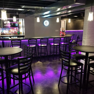 Imagen de sótano con puerta industrial, grande, con paredes grises, suelo de cemento y suelo negro