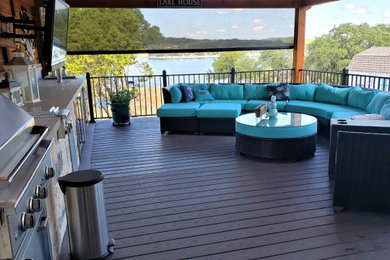 Outdoor kitchen deck - huge eclectic backyard outdoor kitchen deck idea in Austin with a roof extension