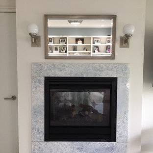 フィラデルフィアの中サイズのモダンスタイルのおしゃれな書斎 (青い壁、カーペット敷き、両方向型暖炉、石材の暖炉まわり、自立型机、青い床) の写真