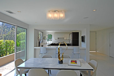 Photo of a modern u-shaped separate kitchen in Los Angeles with flat-panel cabinets and white cabinets.