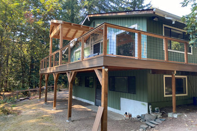 Example of a large arts and crafts backyard second story metal railing deck design in Seattle