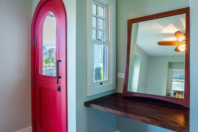 Inspiration for a mid-sized eclectic front door in Hawaii with grey walls, dark hardwood floors, a single front door, a red front door and brown floor.