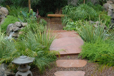 Photo of a large asian partial sun front yard stone landscaping in Phoenix.