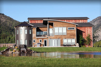 Large urban brown two-story wood house exterior photo in Other with a hip roof