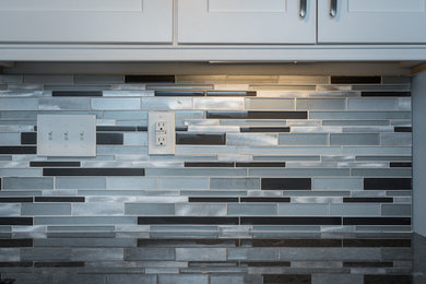This is an example of a mid-sized transitional l-shaped eat-in kitchen in Raleigh with white splashback and glass tile splashback.