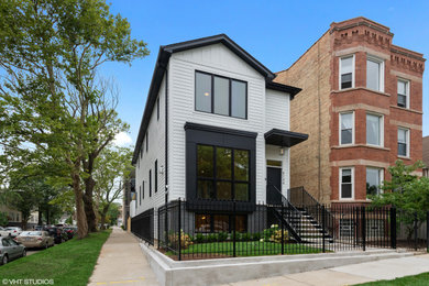 Large minimalist white vinyl exterior home photo in Chicago