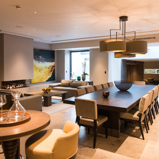 Inspiration för stora moderna matplatser med öppen planlösning, med beige väggar, en bred öppen spis och beiget golv