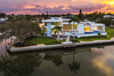 Large minimalist white two-story stucco flat roof photo in Tampa