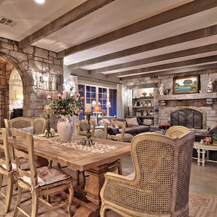 На фото: огромные гостиные-столовые в стиле шебби-шик с бетонным полом и фасадом камина из камня