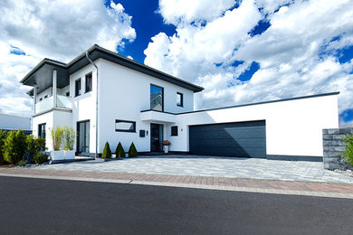 Zweistöckiges Einfamilienhaus mit weißer Fassadenfarbe, Putzfassade, Walmdach, Ziegeldach und schwarzem Dach in Sonstige