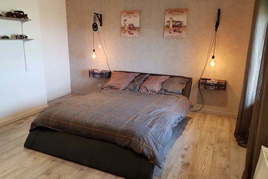 Exemple d'une chambre parentale industrielle de taille moyenne avec un mur beige, sol en stratifié et un sol marron.