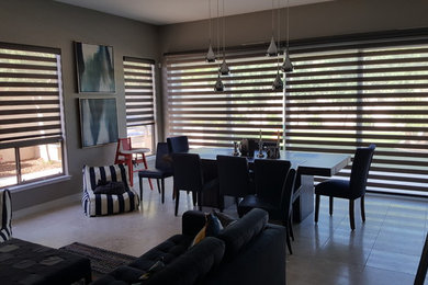 Example of a large minimalist porcelain tile and gray floor great room design in Phoenix with gray walls and no fireplace