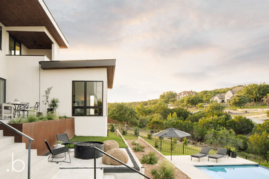 Imagen de fachada de casa minimalista de dos plantas con revestimiento de estuco