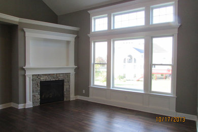 Inspiration for a large craftsman open concept medium tone wood floor living room remodel in Chicago with gray walls, a standard fireplace and a stone fireplace