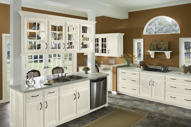 This is an example of a mid-sized traditional kitchen in Dallas with a double-bowl sink, recessed-panel cabinets, white cabinets, solid surface benchtops, slate floors, with island and grey floor.