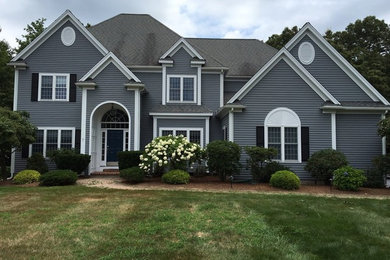 Inspiration for a large modern blue two-story wood house exterior remodel in Boston with a hip roof and a shingle roof