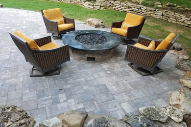 Inspiration for a mid-sized country backyard patio in Kansas City with a fire feature and concrete pavers.