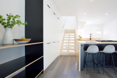Inspiration for a small modern galley bamboo floor and gray floor eat-in kitchen remodel in Other with an undermount sink, flat-panel cabinets, white cabinets, wood countertops, stainless steel appliances and an island