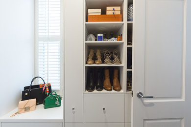 Photo of a mid-sized transitional women's walk-in wardrobe in Melbourne with flat-panel cabinets, white cabinets, carpet and grey floor.