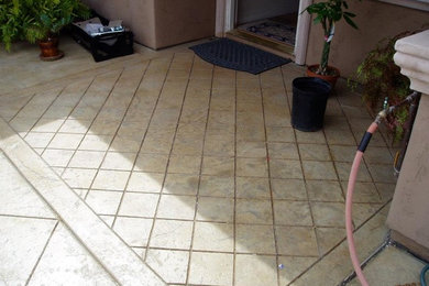 Small elegant backyard concrete paver patio photo in San Diego with a roof extension
