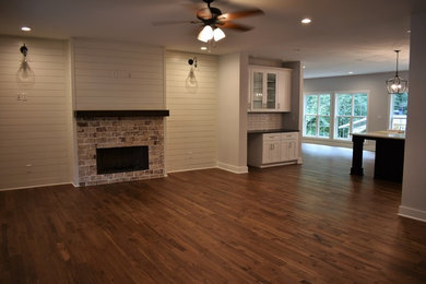 Inspiration for a large country open concept living room in Atlanta with medium hardwood floors, a standard fireplace, a tile fireplace surround, no tv and brown floor.