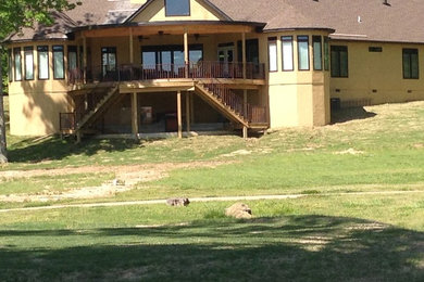 Example of a mountain style yellow one-story stucco exterior home design in Little Rock