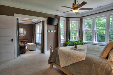 Inspiration for a large master bedroom in Charlotte with brown walls and carpet.