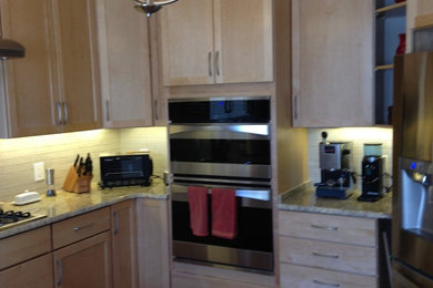 Large trendy u-shaped medium tone wood floor eat-in kitchen photo in Baltimore with a double-bowl sink, shaker cabinets, light wood cabinets, granite countertops, multicolored backsplash, porcelain backsplash, stainless steel appliances and a peninsula