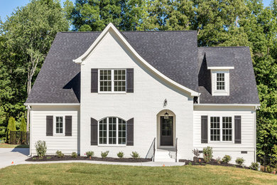 Mid-sized traditional white two-story brick exterior home idea in Other with a shingle roof