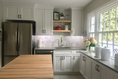 Example of a small transitional u-shaped porcelain tile and gray floor enclosed kitchen design in DC Metro with a single-bowl sink, recessed-panel cabinets, white cabinets, quartz countertops, gray backsplash, marble backsplash, stainless steel appliances, an island and gray countertops