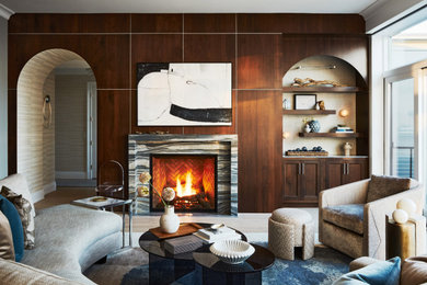 Living room - large coastal open concept light wood floor, wood wall and beige floor living room idea in Boston with brown walls, a standard fireplace, a stone fireplace and a concealed tv