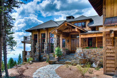 Huge mountain style brown three-story wood exterior home photo in Other
