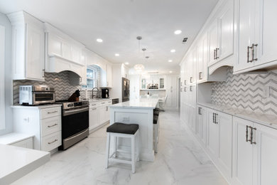 Design ideas for a large contemporary galley eat-in kitchen in Philadelphia with an undermount sink, shaker cabinets, white cabinets, quartz benchtops, white splashback, marble splashback, stainless steel appliances, porcelain floors, with island, white floor and white benchtop.
