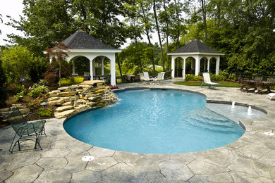 Inspiration for a mid-sized backyard stamped concrete and custom-shaped natural pool remodel in Cincinnati